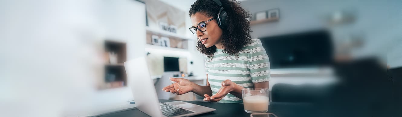 A young woman wearing headphones talks to others during a remote mediation