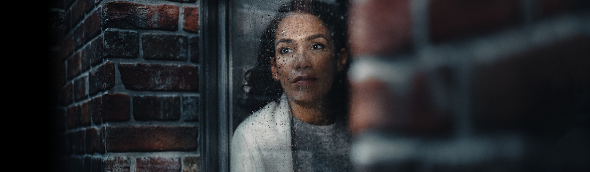 Moody image of woman staring out of window